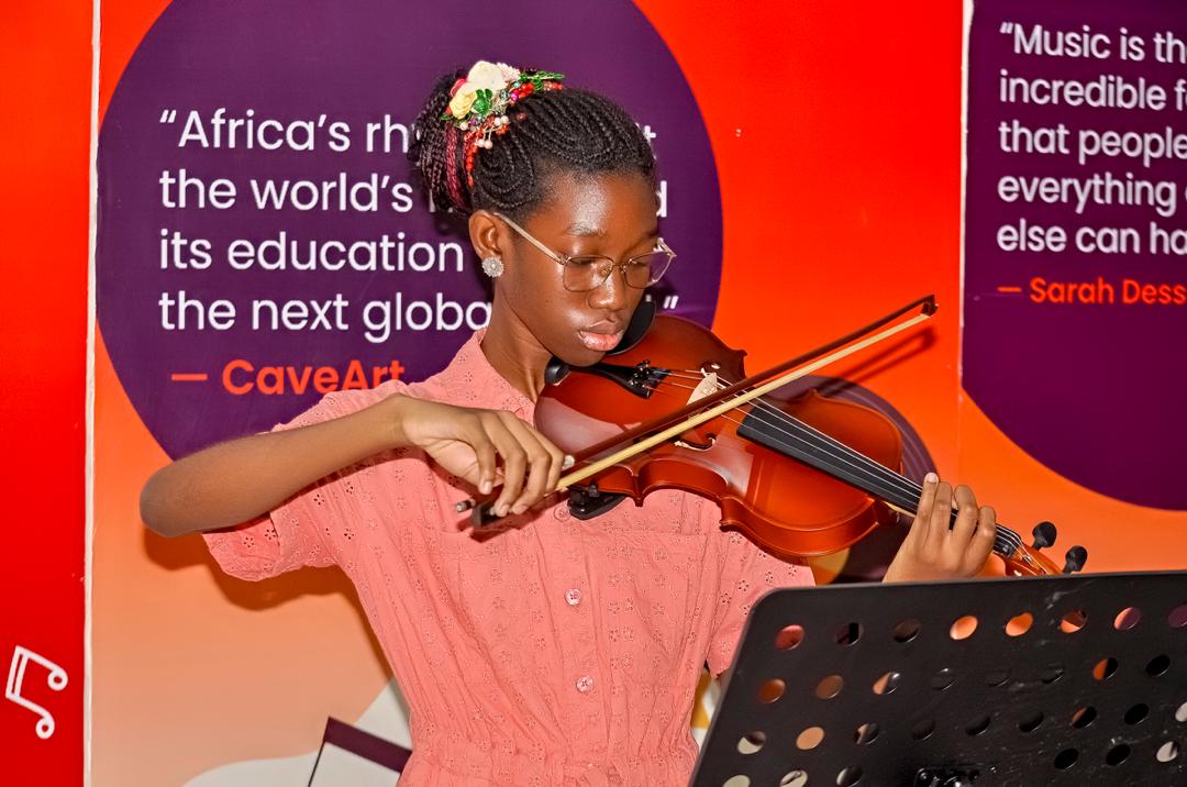 Young violinist performing in front of quote wall
